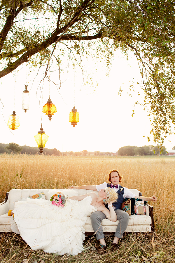 Couple lounging on outdoor sofa with vintage inspired lights hanging from the trees - Photos by Studio 6.23
